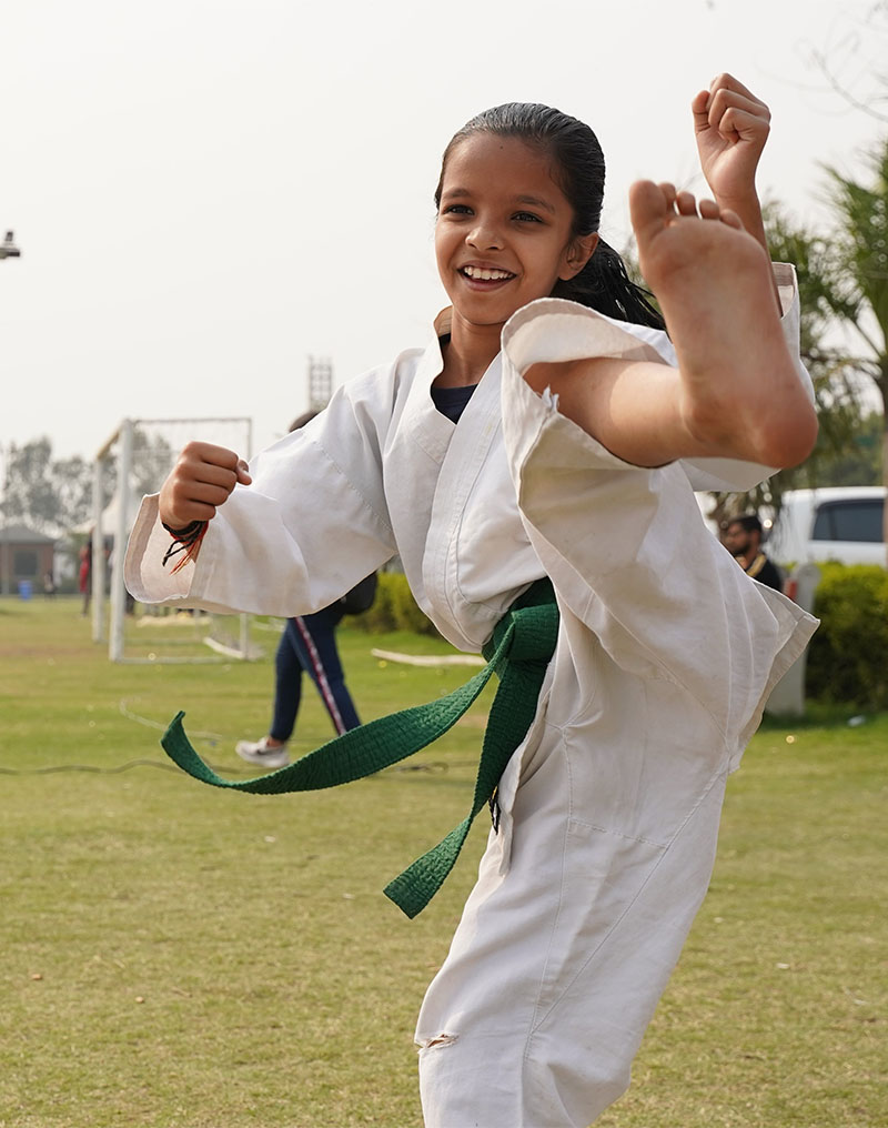 Young girl wearing a Karate suite kicking