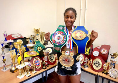 Shanelle Dyer holding MMA Belts and Trophies